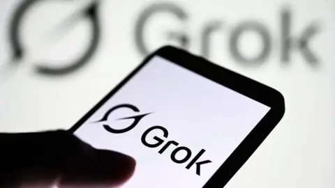 Aplicativo do Grok aberto na tela de um celular, com o logotipo da xAI ao fundo