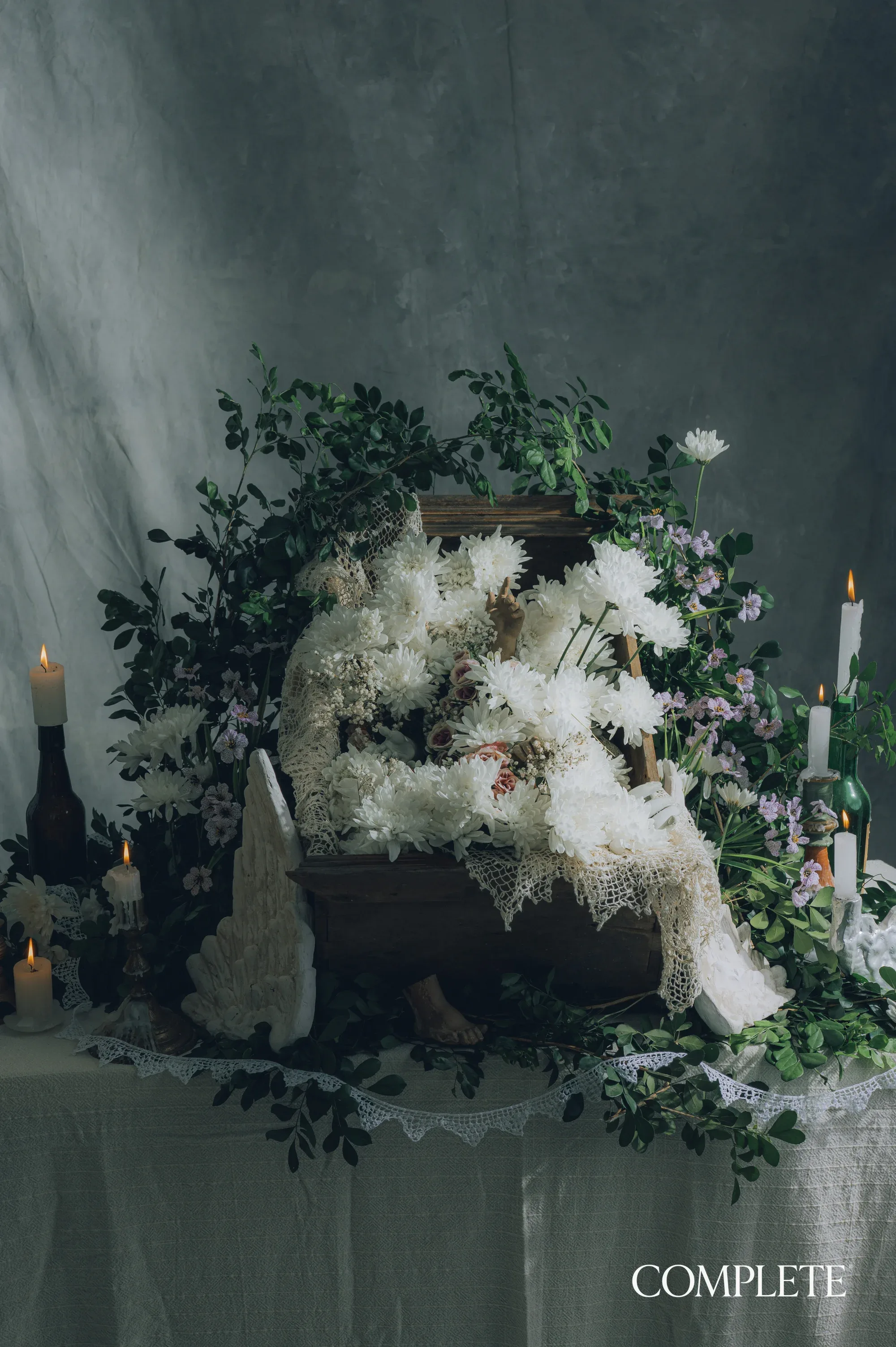 O altar do Angelito: crisântemos brancos, velas e a renda.